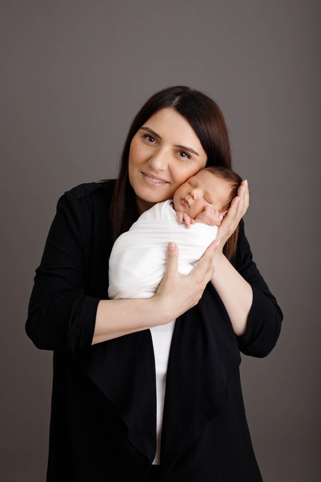 Mother holding her swaddled newborn — family photo session in Tbilisi