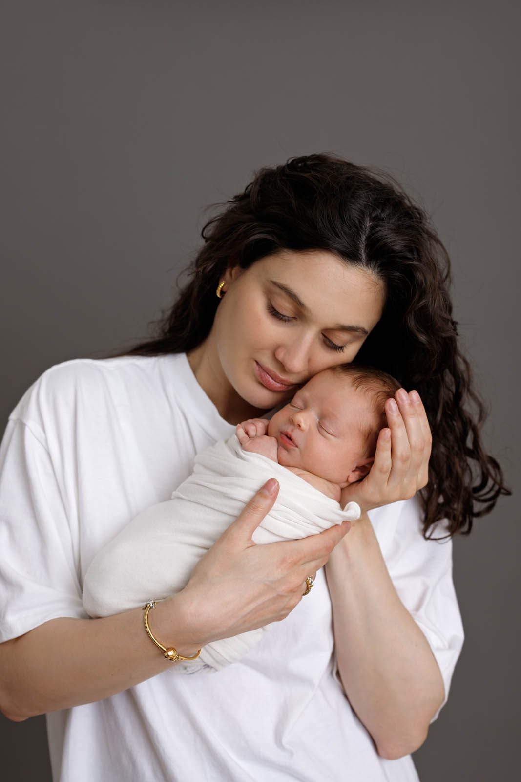 Mother cradling her newborn baby — family session in Tbilisi