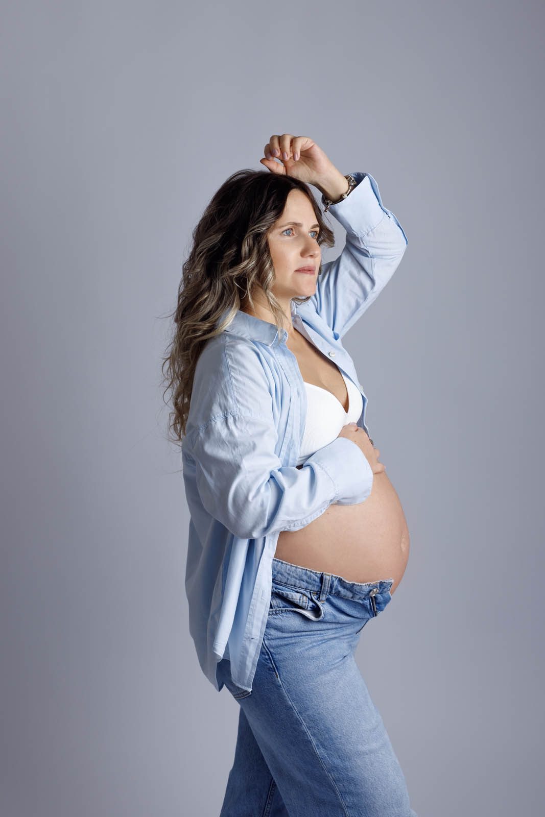 Expecting mother in a blue shirt and jeans — maternity photography Tbilisi