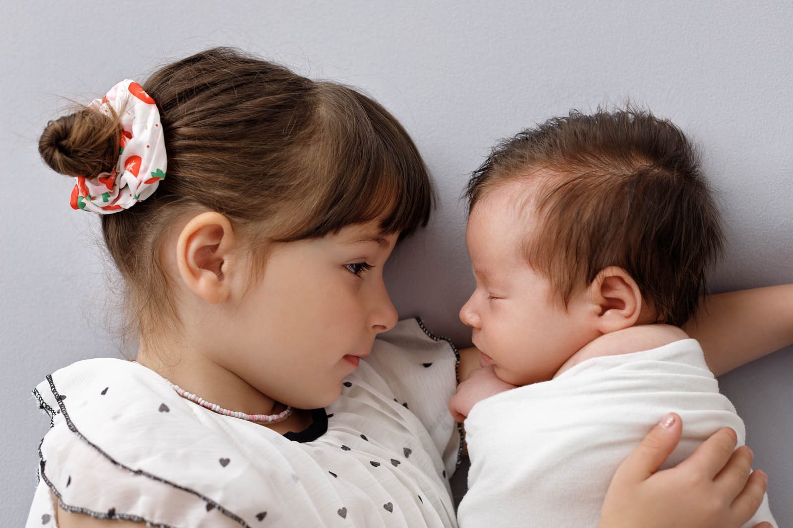 Newborn and baby held in soft backlight — Studio Muffin, Tbilisi