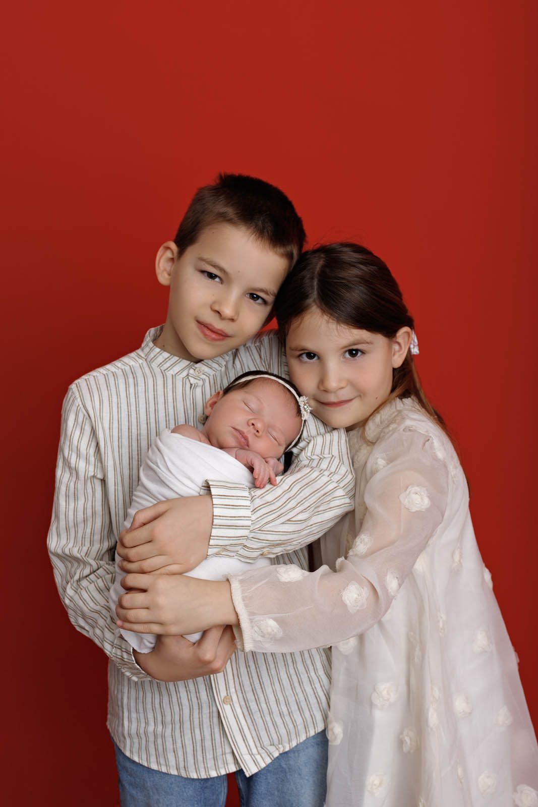 Two siblings with their newborn, foreheads touching — Tbilisi